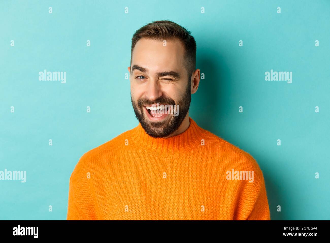 confident handsome caucasian man winking and smiling at camera on blue studio background stock photo alamy confident handsome caucasian man winking and smiling at camera on blue studio background stock photo alamy