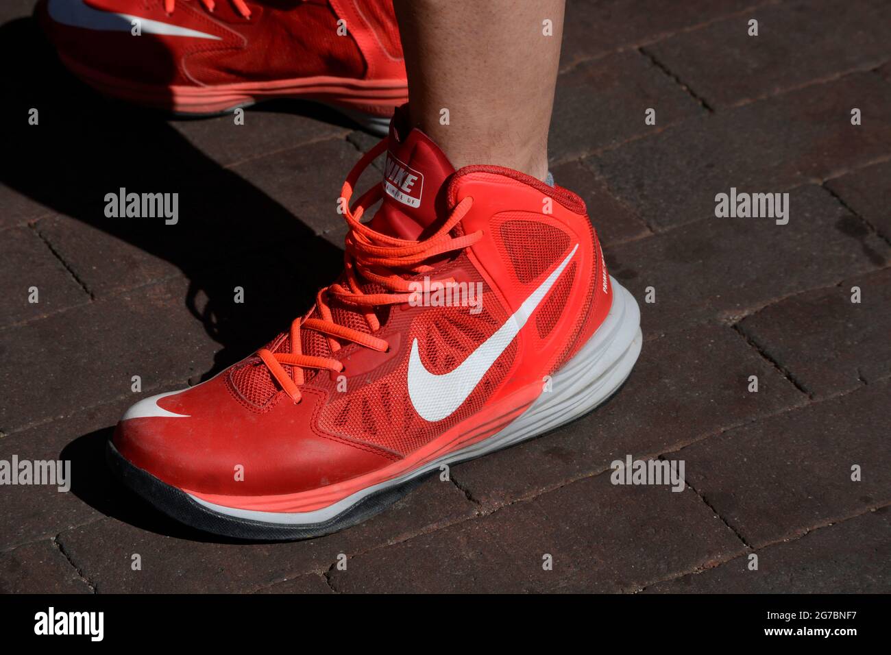 A red nike tennis shoes man wears a pair of red Nike Prime Hype DF tennis or athletic