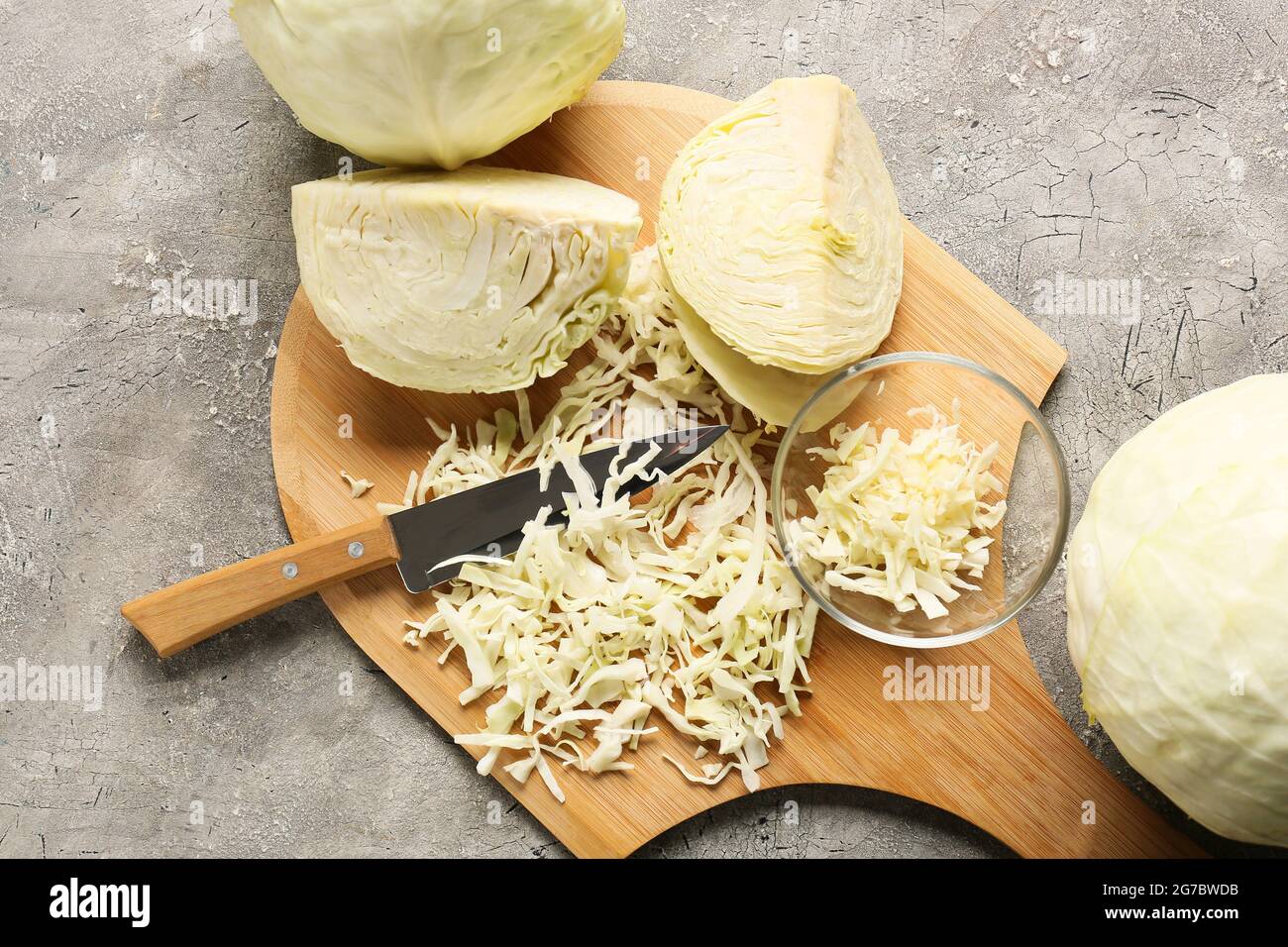 Wooden board with fresh chopped cabbage on grunge background Stock ...