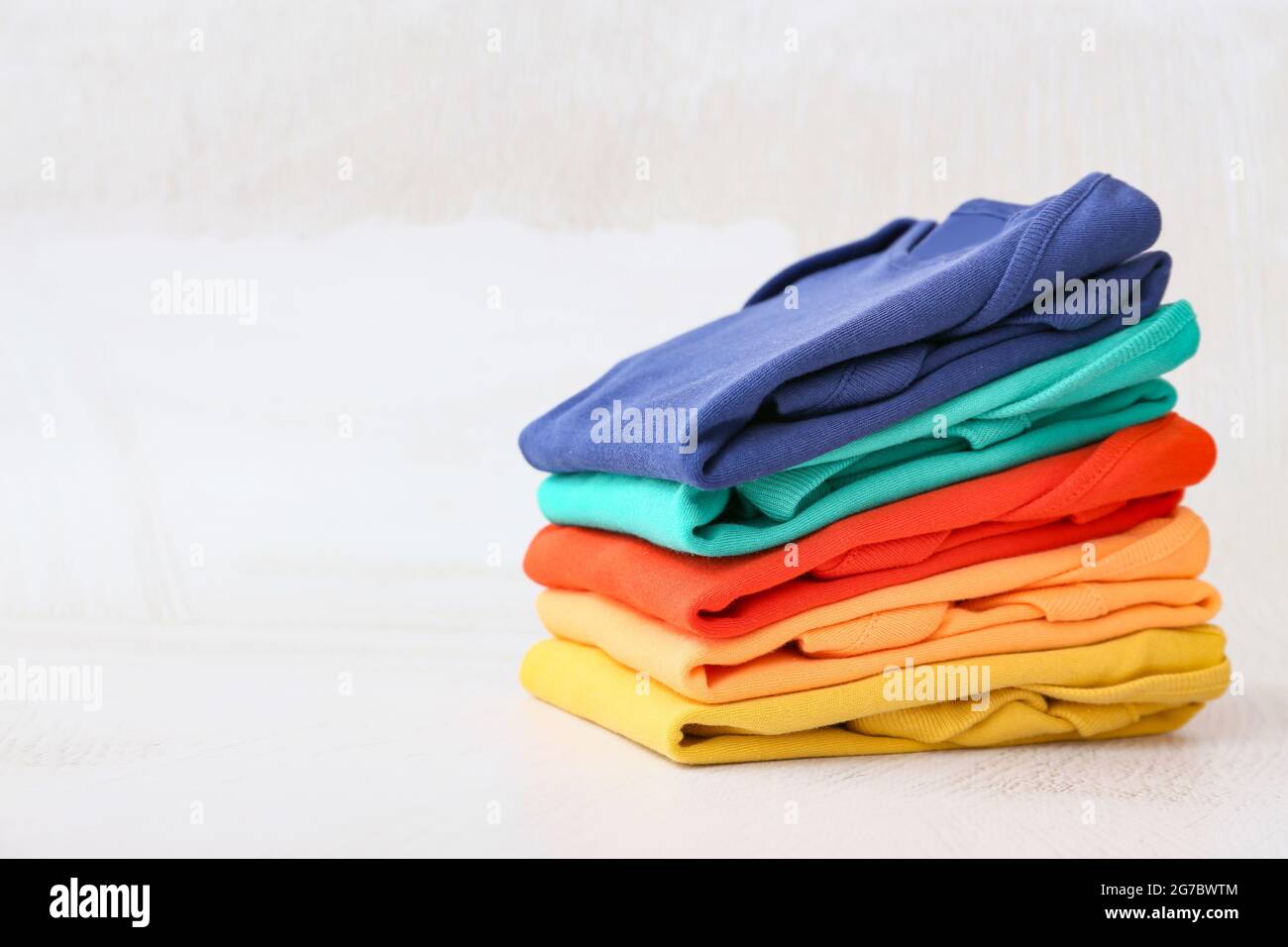 Stack of baby clothes on light background Stock Photo - Alamy