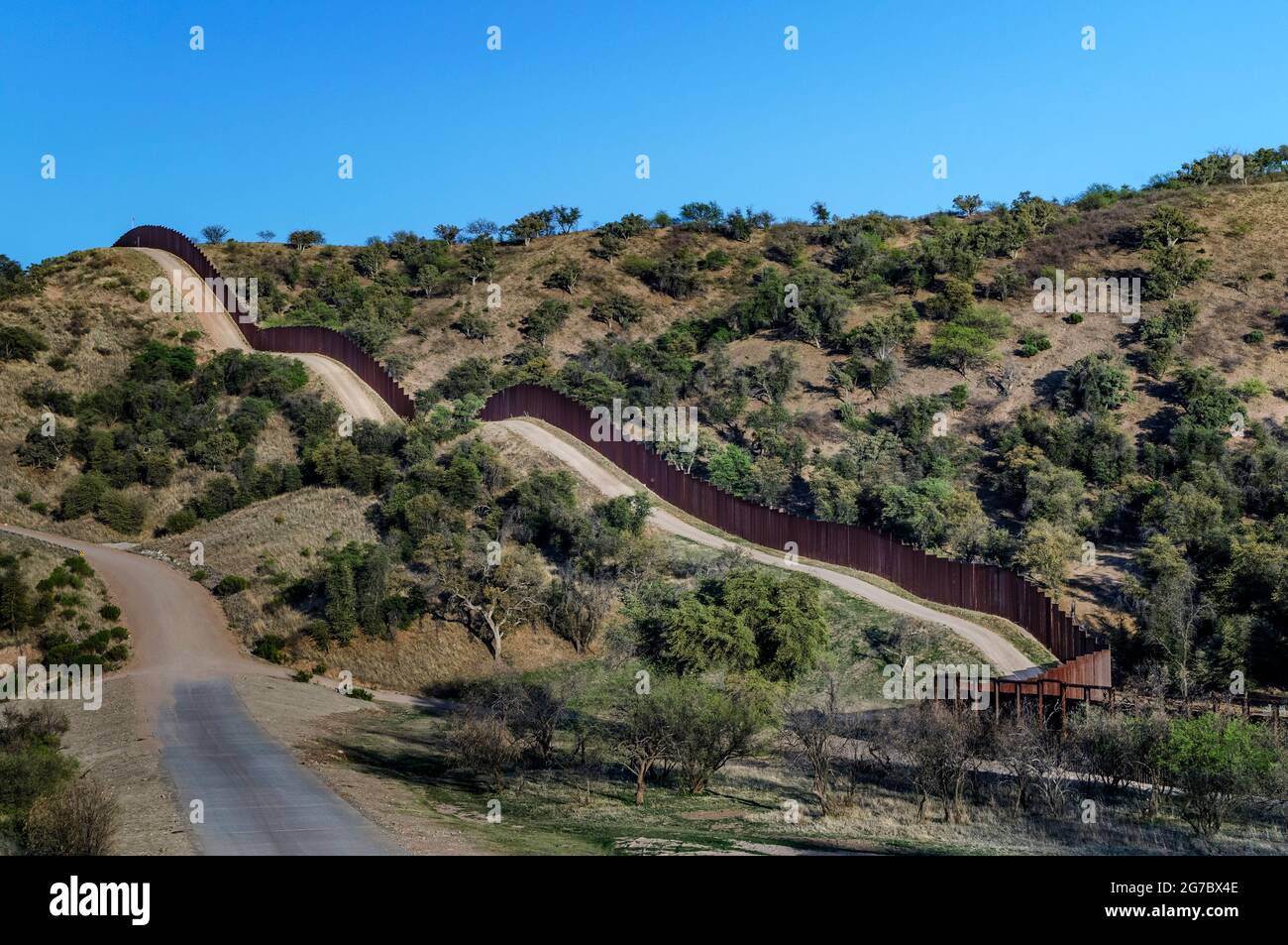 US border fence (pedestrian barrier) on the Mexico border, west of Nogales Arizona and Nogales Sonora Mexico, viewed from US Side, looking southeast; Stock Photo
