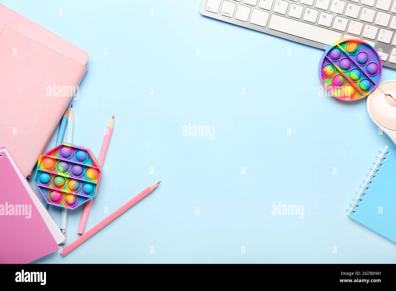 Pop it fidget toy, stationery and PC keyboard on color background Stock ...
