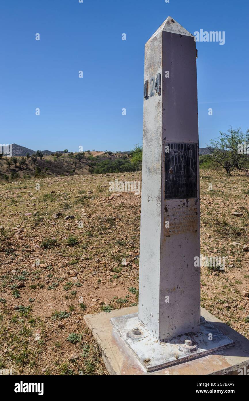 Image shows historic US boundary monument on the Mexico border, west of Nogales Arizona and Nogales Sonora Mexico . The actual fence is just out of vi Stock Photo