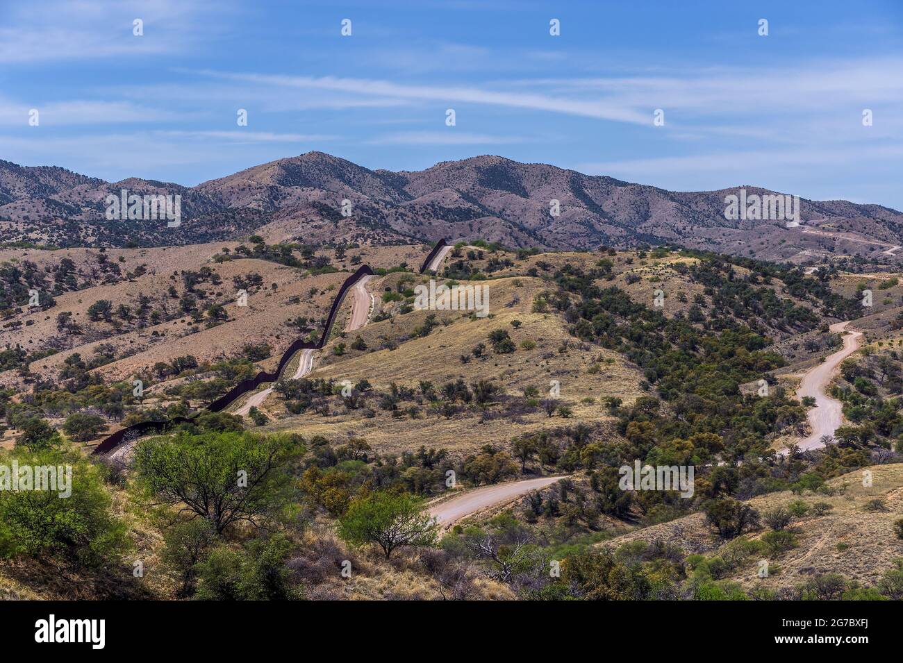 US border fence on the Mexico border, viewed looking west, from about 2 miles west of Nogales Arizona and Nogales Sonora Mexico.  This is an older typ Stock Photo