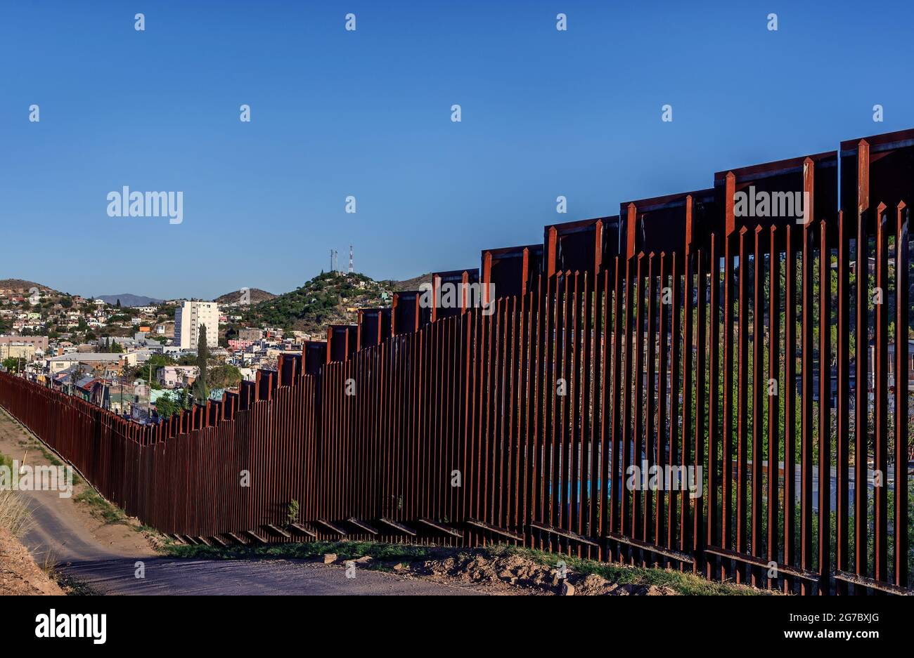 US border fence, “bollard” style construction, serving as pedestrian barrier, viewed from US side in Nogales Arizona USA, with Nogales Sonora Mexico o Stock Photo