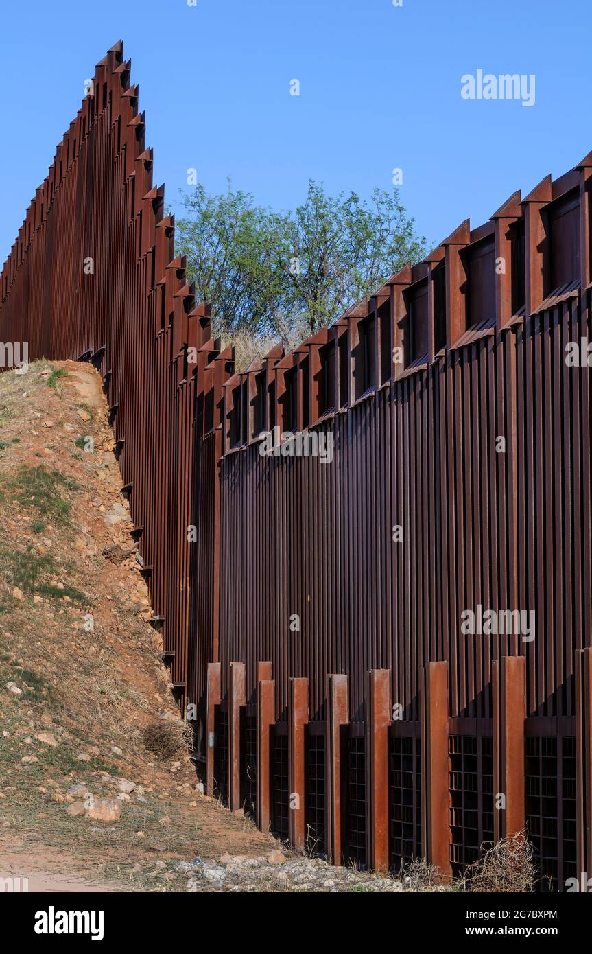 US border fence on the Mexico border, east of Nogales Arizona USA and Nogales Sonora Mexico, viewed from US side, looking east. This type of barrier i Stock Photo