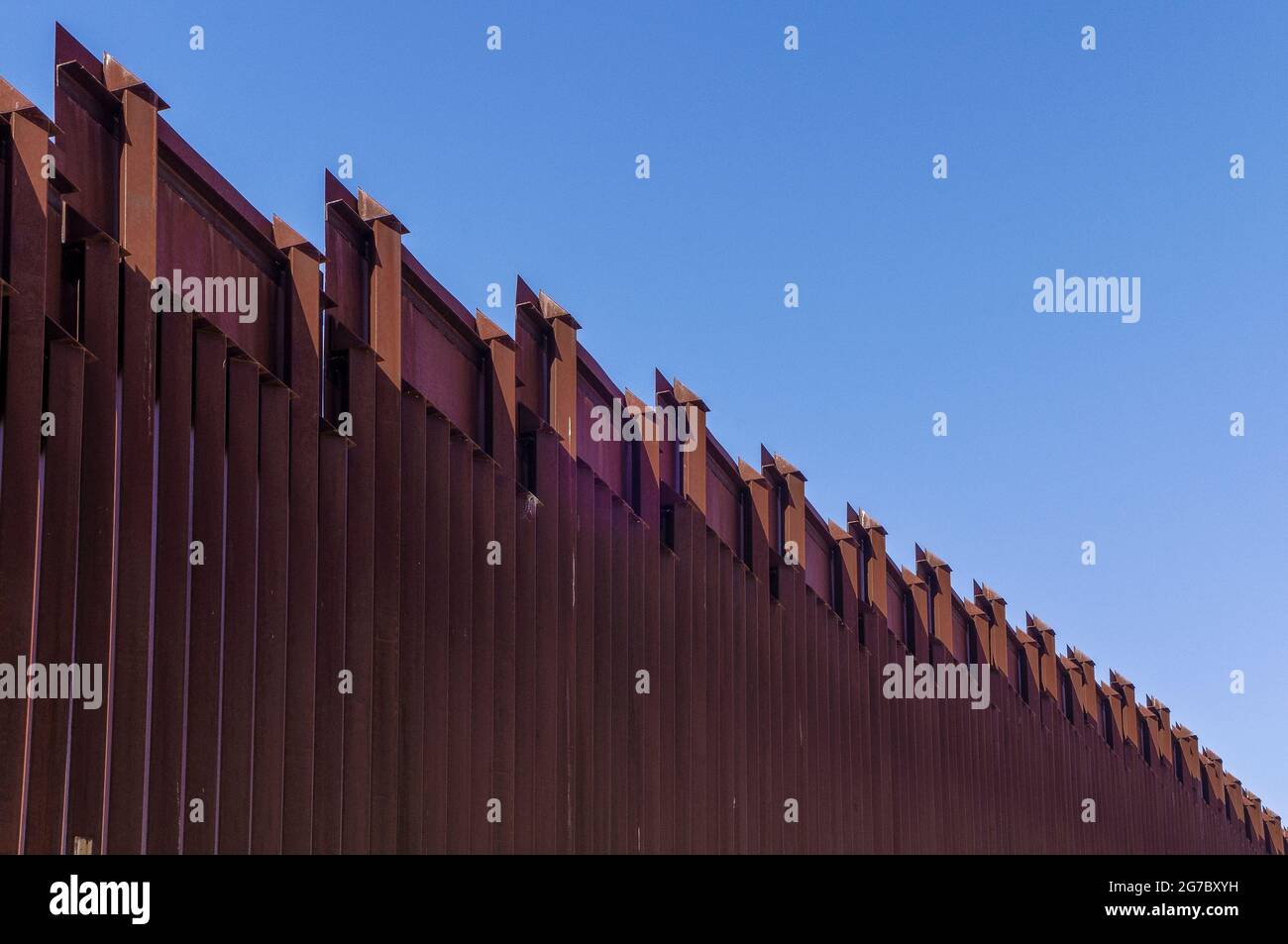 Image shows US border fence on the Mexico border, east of Nogales Arizona and Nogales Sonora Mexico, viewed from US side.This type of barrier is “boll Stock Photo