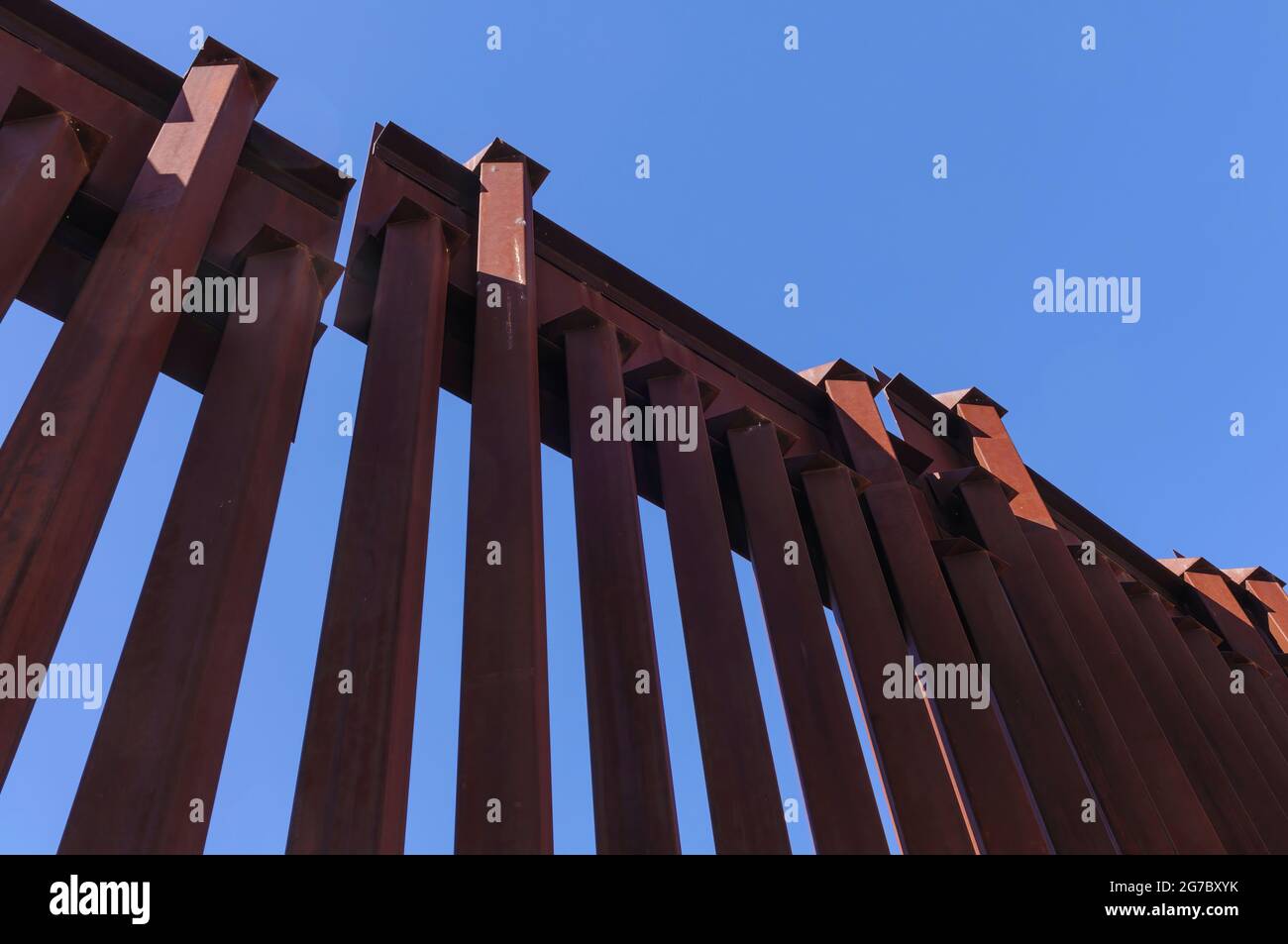 Image shows US border fence on the Mexico border, east of Nogales Arizona and Nogales Sonora Mexico, viewed from US side.This type of barrier is “boll Stock Photo