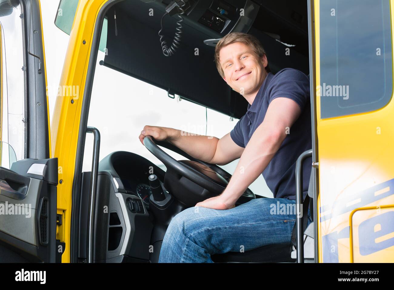 Logistics - proud driver or forwarder in drivers cap of truck and ...