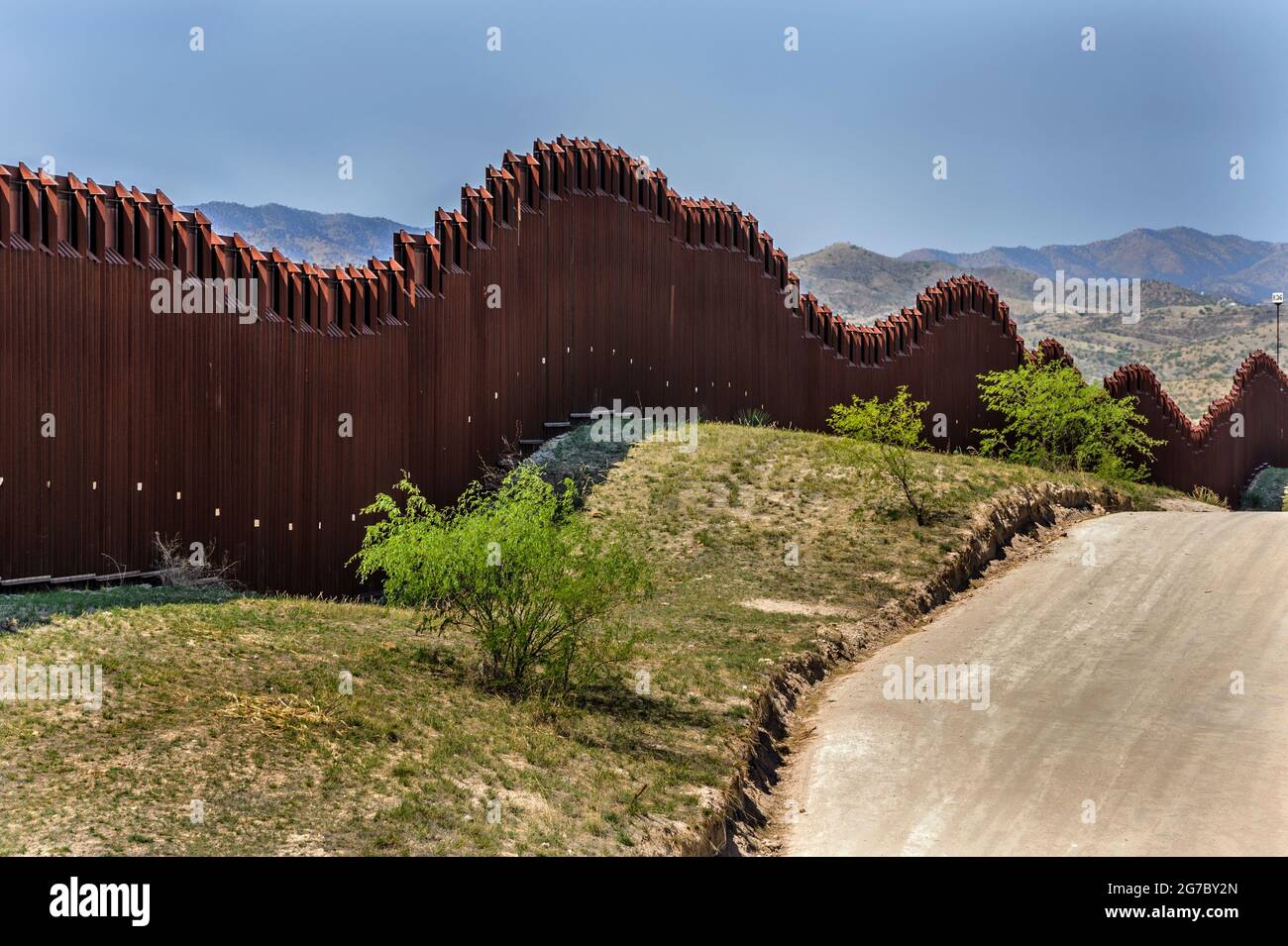 US border fence on the Mexico border, east of Nogales Arizona USA and Nogales Sonora Mexico, viewed from US side. This type of barrier is “bollard” st Stock Photo