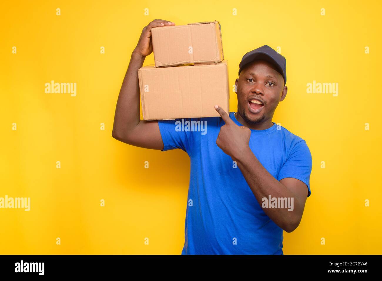 An African dispatch man with face cap, pointing to the boxes he is carrying on his shoulder Stock Photo