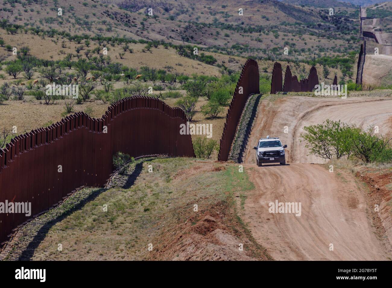 US border fence on the Mexico border, east of Nogales Arizona USA, and Nogales Sonora Mexico, viewed from US side, with US Border Patrol vehicle. Stock Photo