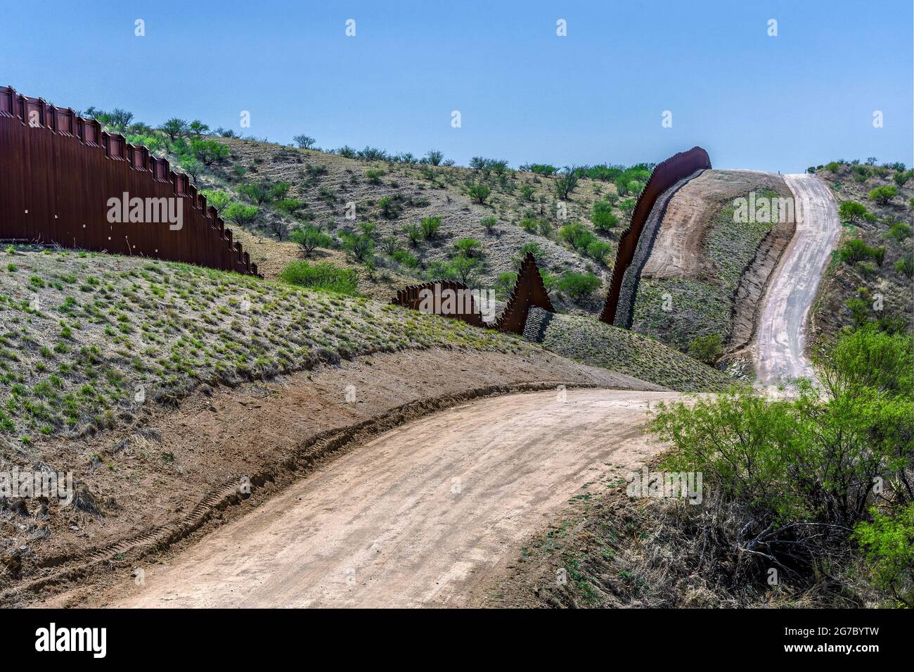 US border fence on the Mexico border, east of Nogales Arizona USA, and Nogales Sonora Mexico, viewed from US side. This type of barrier is “bollard” s Stock Photo