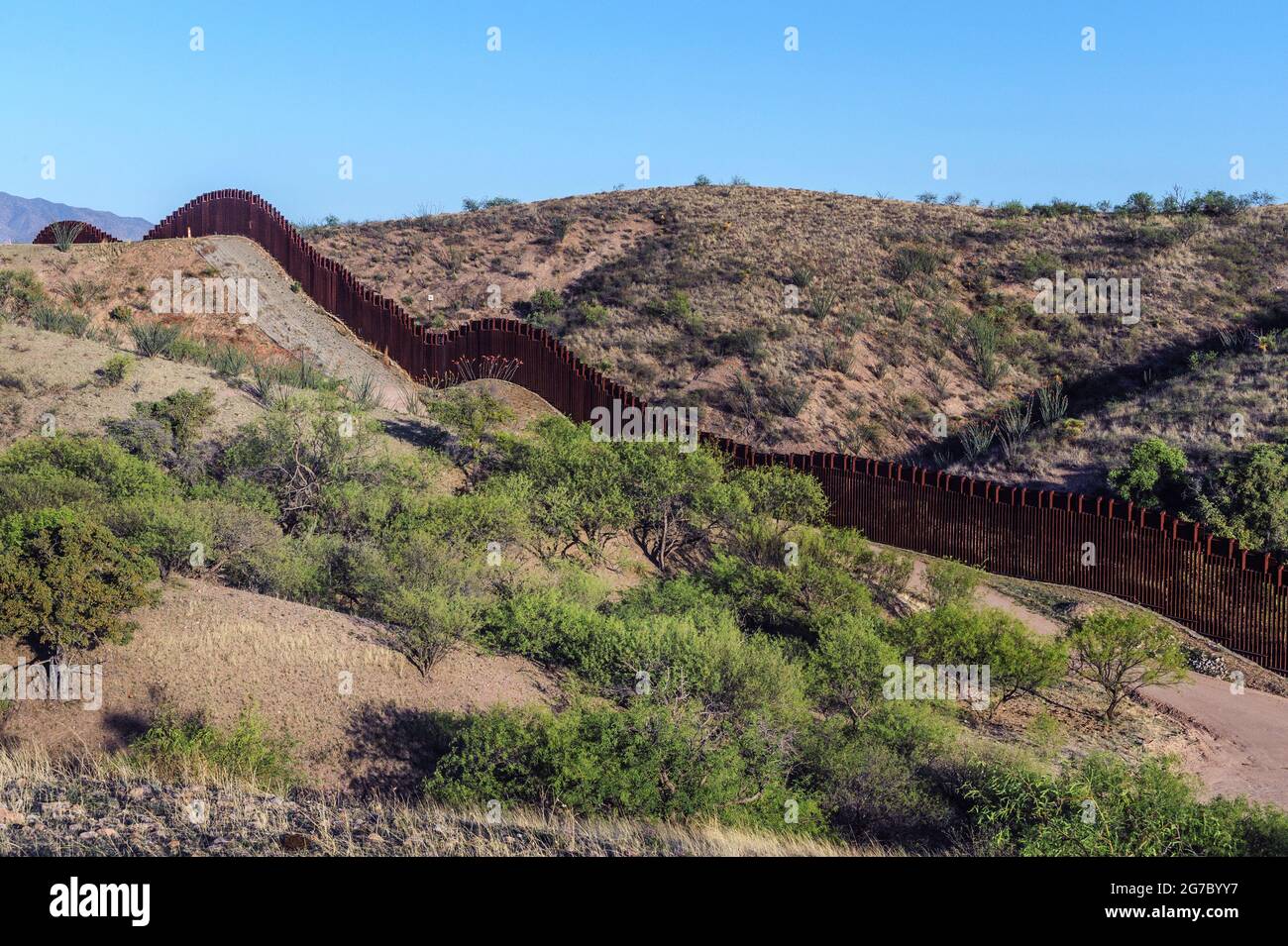 US border fence on the Mexico border, east of Nogales Arizona USA, and Nogales Sonora Mexico, viewed from US side. This type of barrier is “bollard” s Stock Photo