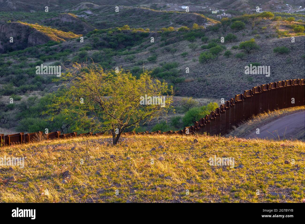 US border fence on the Mexico border, east of Nogales Arizona USA, and Nogales Sonora Mexico, viewed from US side. This type of barrier is “bollard” s Stock Photo