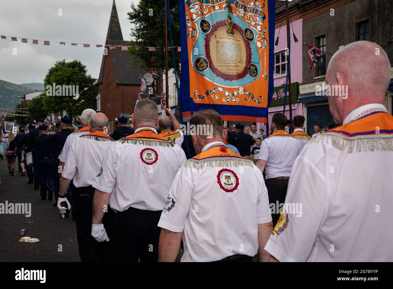 Orangemen march through the staunchly Loyalist Shankill Road during the annual July 12th parades. The annual 12th of July Orange Order parades took place this year after a hiatus due to the pandemic. Despite speculations of a potentially heated weekend due to the Brexit protocols and recent related tensions as well as certain contentions bonfire builds throughout the North, the festivities passed peacefully. The parade season marks the anniversary of the protestant King William of Orange's victory over the Catholic forces of King James at the Battle of the Boyne in 1690. (Photo by Graham Marti Stock Photo