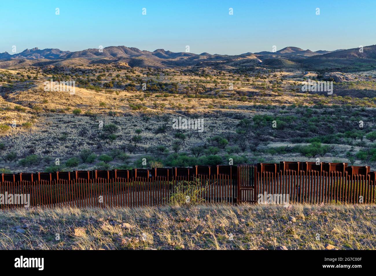 US border fence on the Mexico border, east of Nogales Arizona USA, and Nogales Sonora Mexico, viewed from US side. This type of barrier i “bollard” s Stock Photo