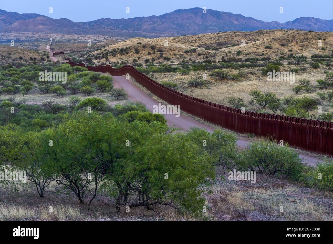 US border fence on the Mexico border, about 5 miles east of Nogales Arizona USA, and Nogales Sonora Mexico, viewed from US side, looking east. This ty Stock Photo