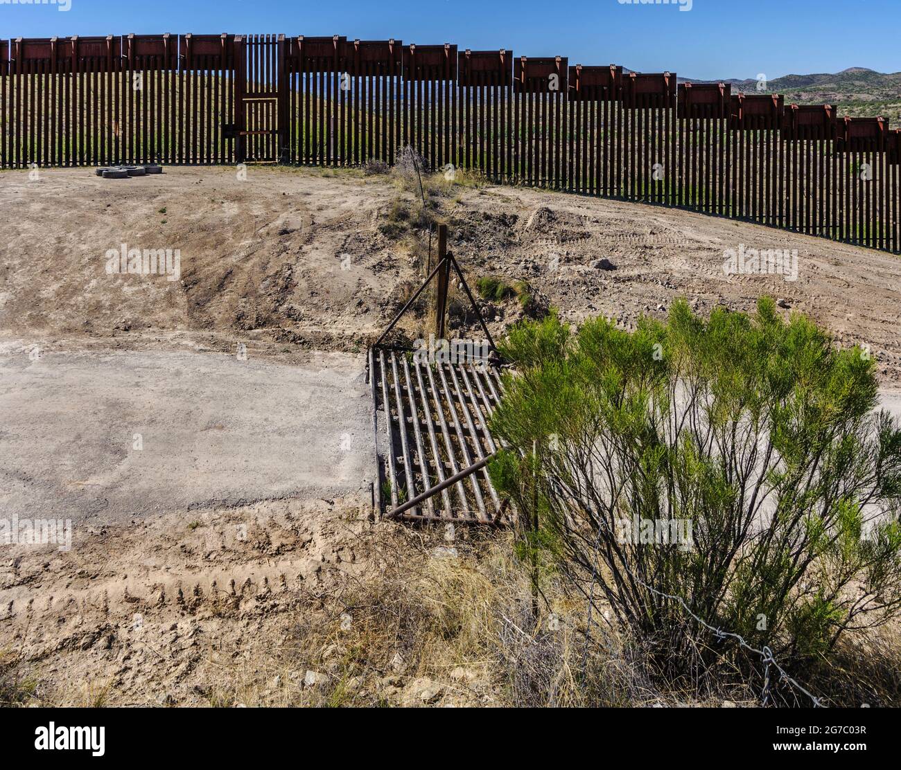 US border fence on the Mexico border, east of Nogales Arizona USA, and Nogales Sonora Mexico, viewed from US side. This type of barrier is “bollard” s Stock Photo