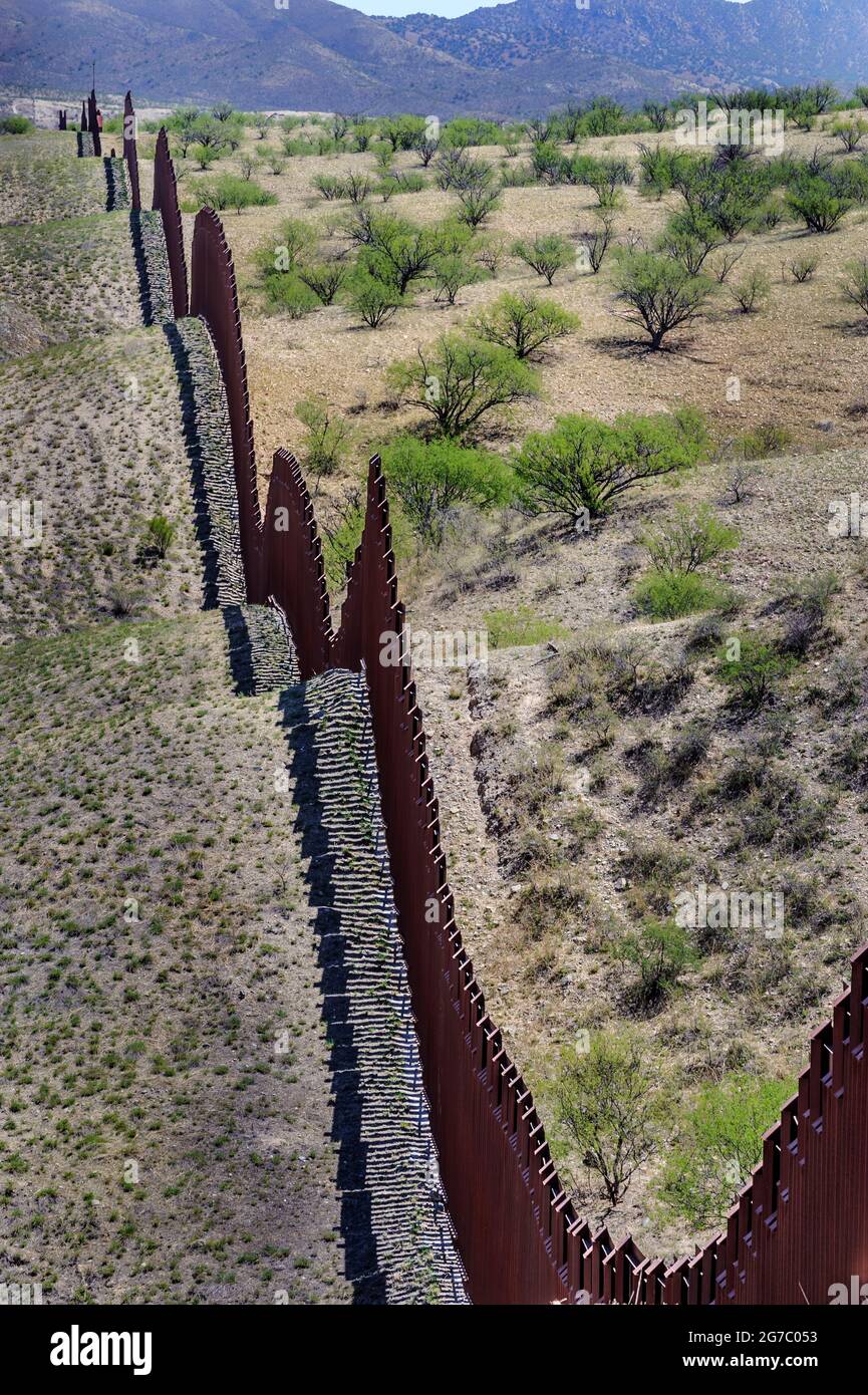 US border fence on the Mexico border, east of Nogales Arizona USA, and Nogales Sonora Mexico, viewed from US side. This type of barrier is “bollard” s Stock Photo