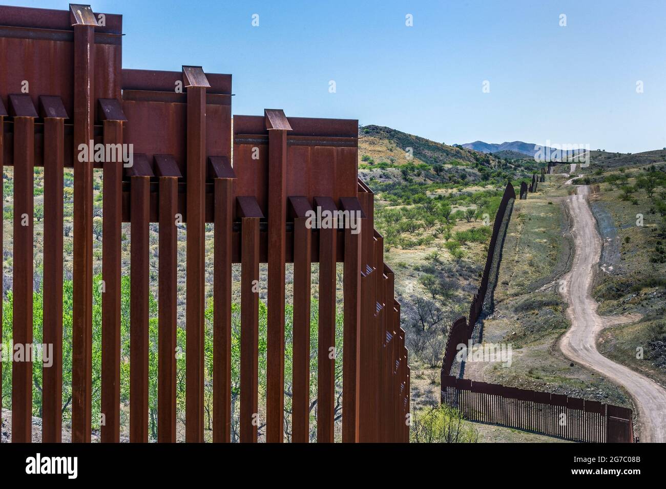 View from a hilltop of US border fence on the Mexico border, east of Nogales Arizona USA, and Nogales Sonora Mexico, viewed from US side. This type of Stock Photo