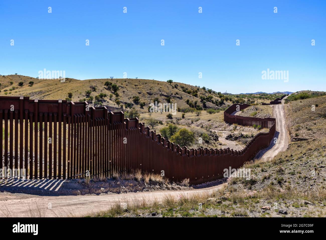 US border fence on the Mexico border, east of Nogales Arizona USA, and Nogales Sonora Mexico, viewed from US side. This view shows fence route being a Stock Photo