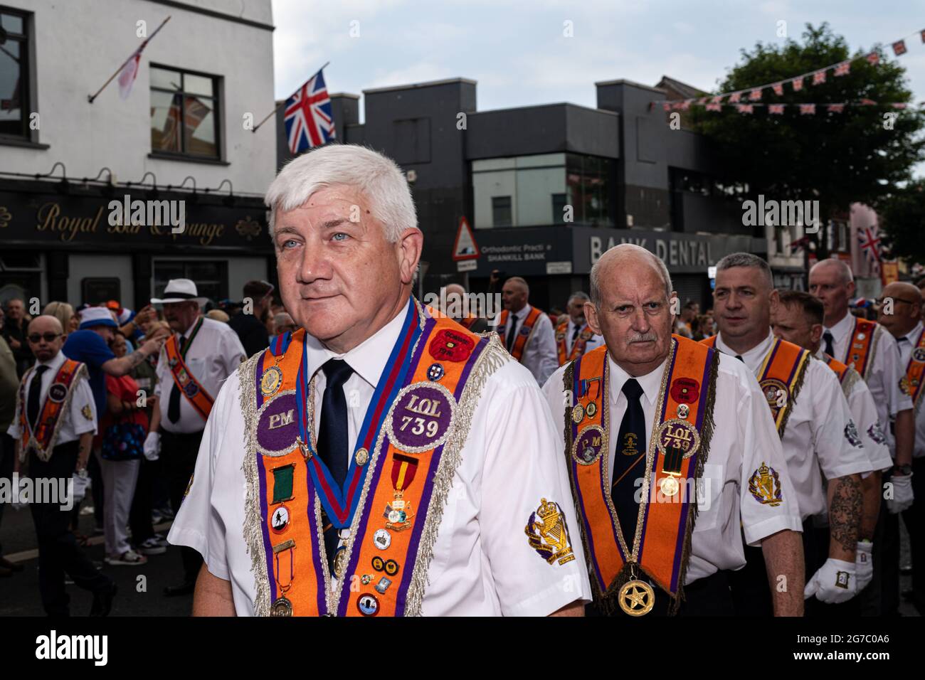 Orangemen march through the staunchly Loyalist Shankill Road during the annual July 12th parades. The annual 12th of July Orange Order parades took place this year after a hiatus due to the pandemic. Despite speculations of a potentially heated weekend due to the Brexit protocols and recent related tensions as well as certain contentions bonfire builds throughout the North, the festivities passed peacefully. The parade season marks the anniversary of the protestant King William of Orange's victory over the Catholic forces of King James at the Battle of the Boyne in 1690. Stock Photo