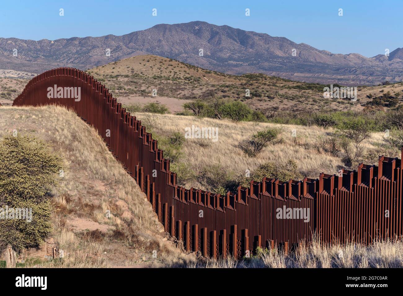 US border fence on the Mexico border, east of Nogales Arizona USA, and Nogales Sonora Mexico, viewed from US side, showing how fence construction foll Stock Photo