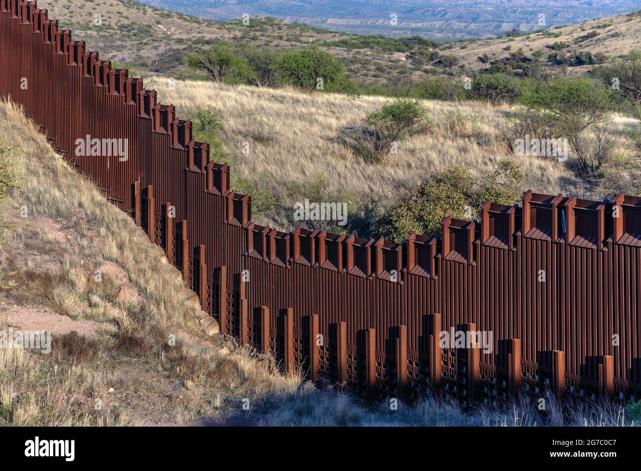 US border fence on the Mexico border, east of Nogales Arizona USA, and Nogales Sonora Mexico, viewed from US side. This type of barrier is “bollard” s Stock Photo