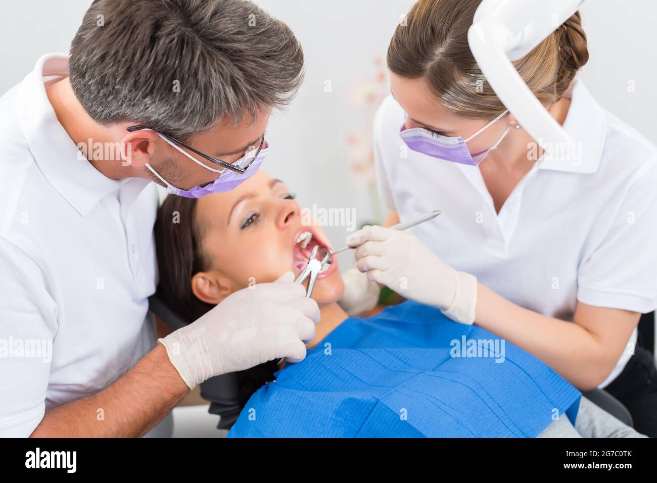 Female patient with dentist and assistant in a dental treatment