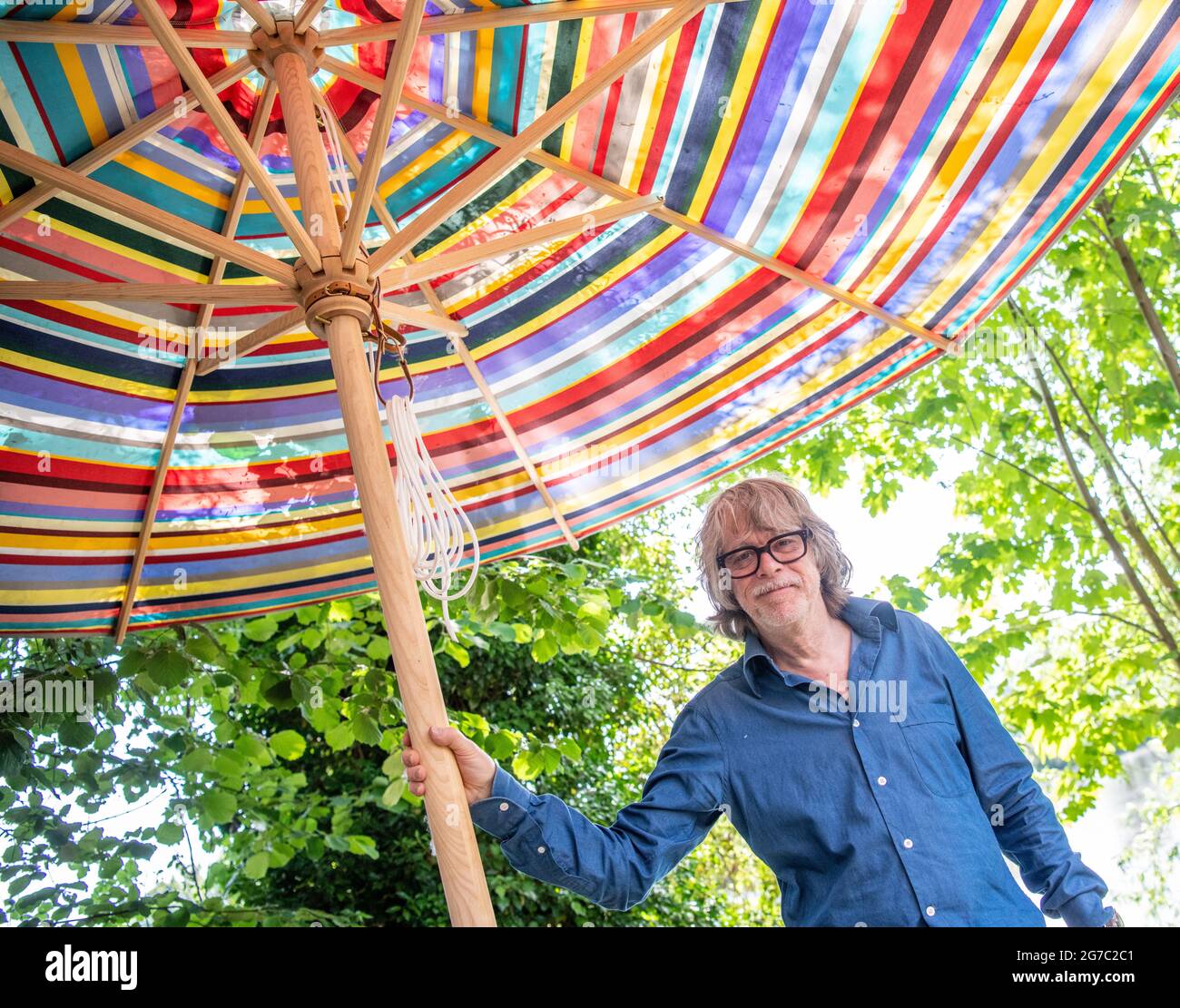 Essen, Germany. 17th June, 2021. Helge Schneider, musician relaxes in his  garden under a colorful parasol. His new album is called "The Last Jazz  Vol. II" and will be released on July