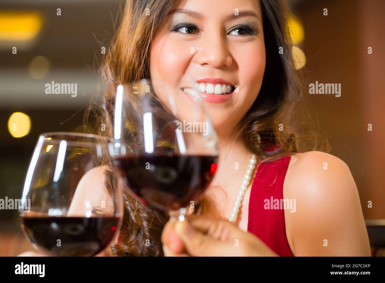 Young woman in  red dress cheers Stock Photo