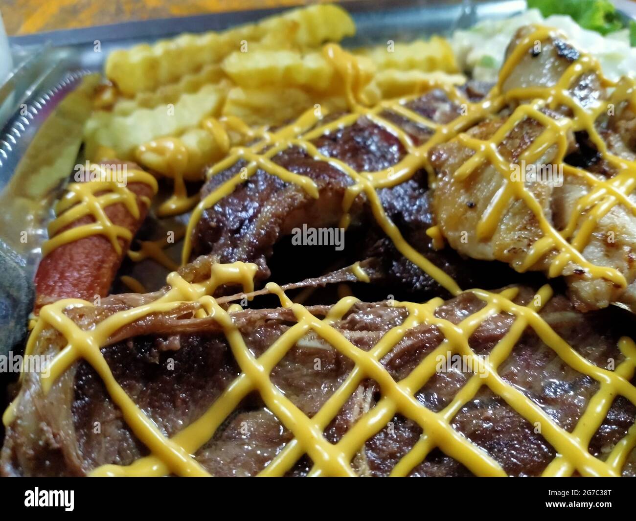 full plater steak with combination of cheese serve along with sausage and fries for full pleasure experience of food Stock Photo