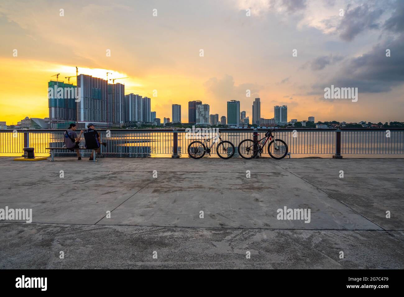 Cyclists taking a break at Woodlands Waterfront Park, a coastal park in central Singapore. Stock Photo