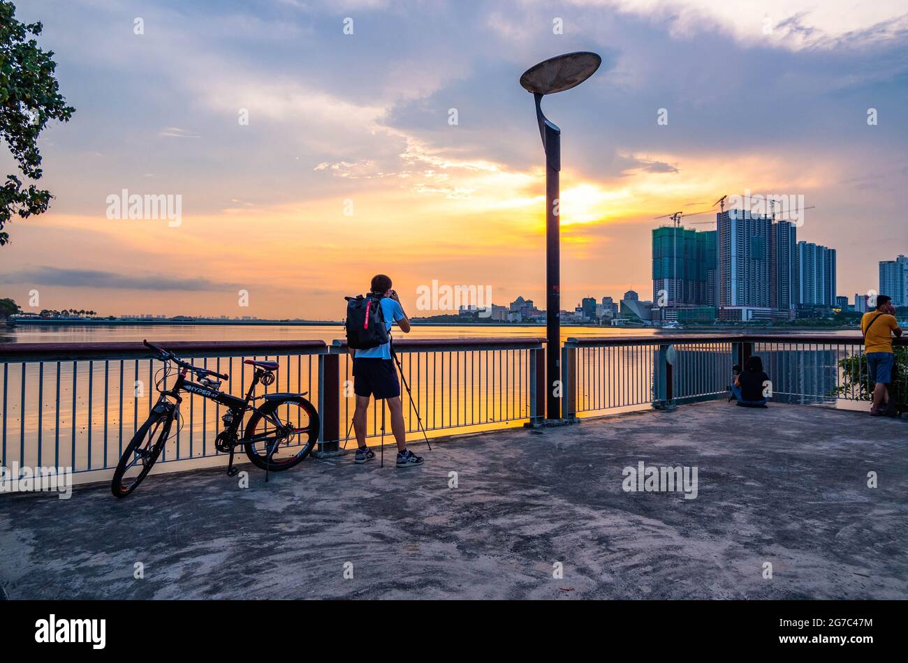 Man photographing sunset at the central coastline of Singapore. Stock Photo