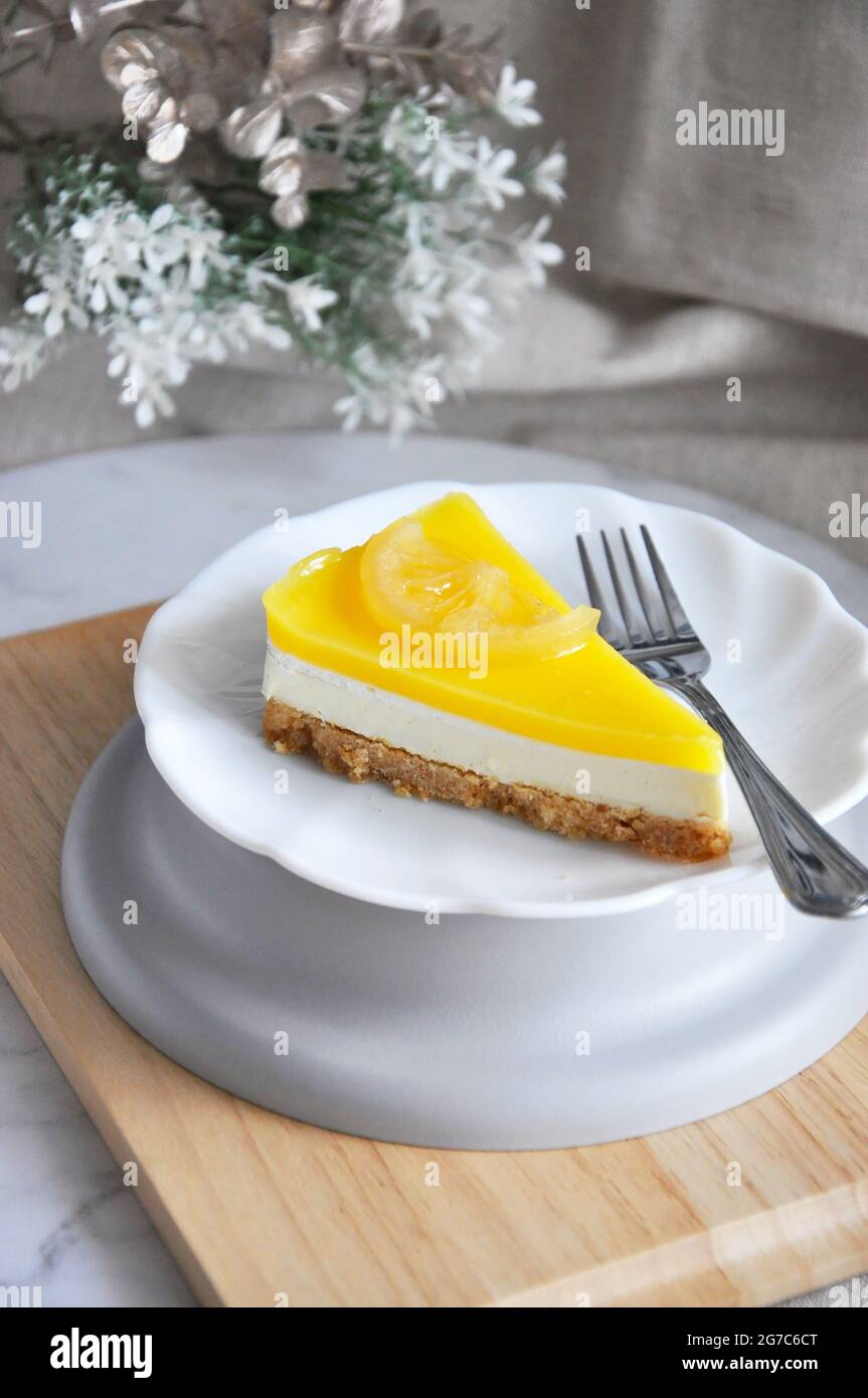 Serving a piece of lemon cheese tart on white plate with copy space on neutral color background Stock Photo
