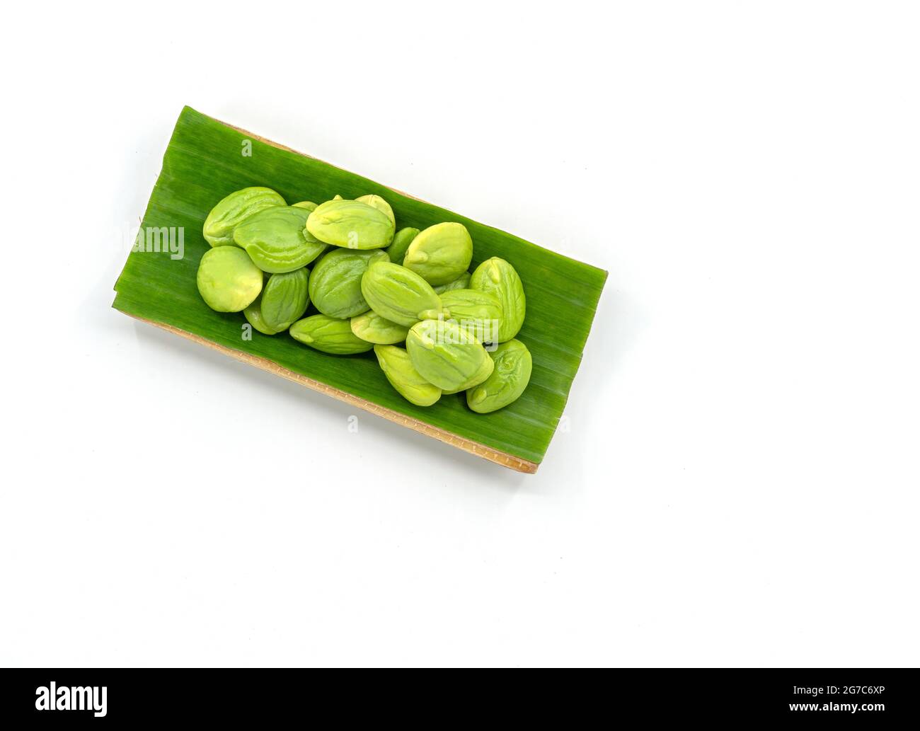 Top view fresh bitter beans in the natural tray by banana leaf for sale on white background, bitter beans or Sator in Thailand language. Stock Photo
