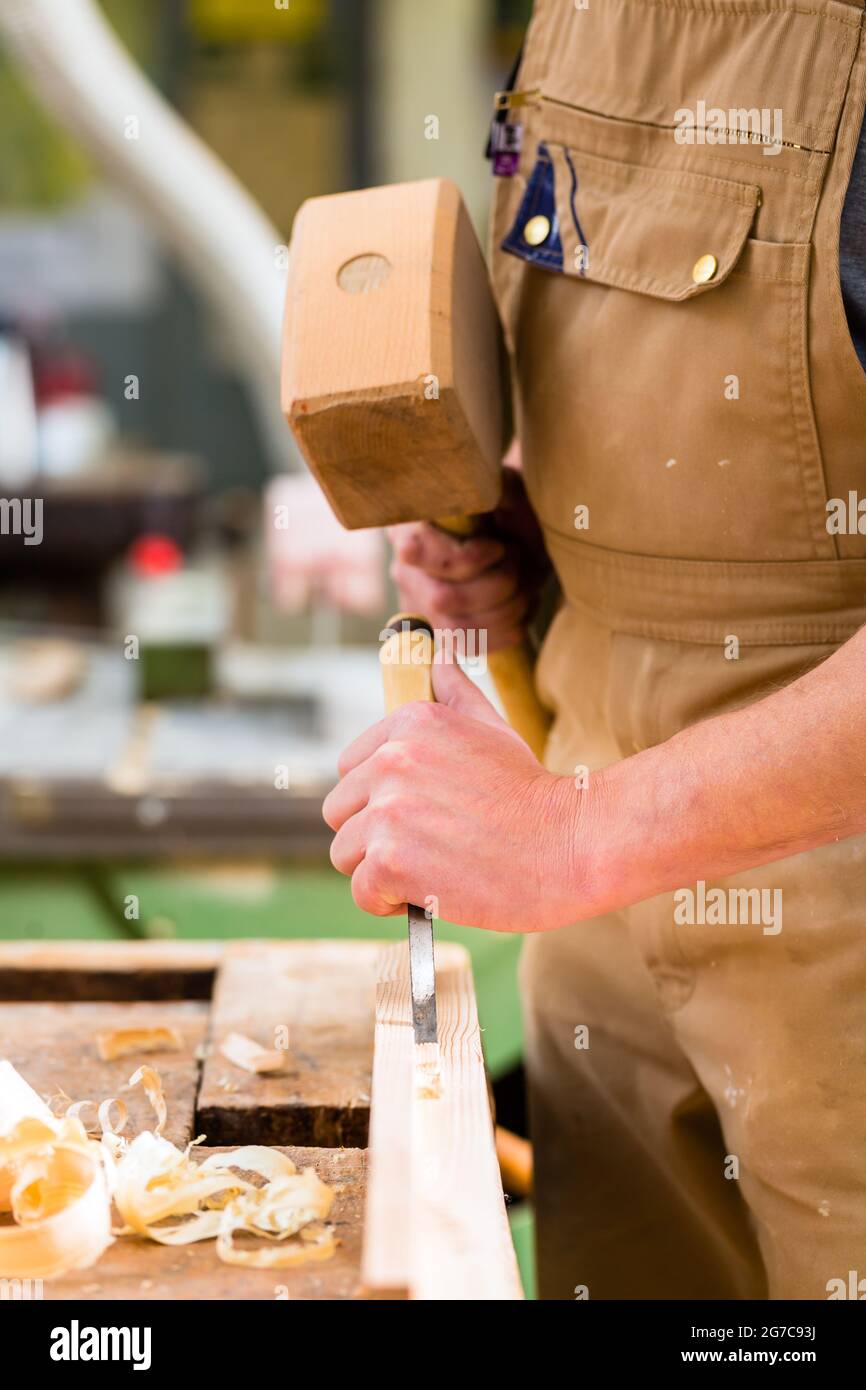 Carpenter with chisel and hammer Stock Photo
