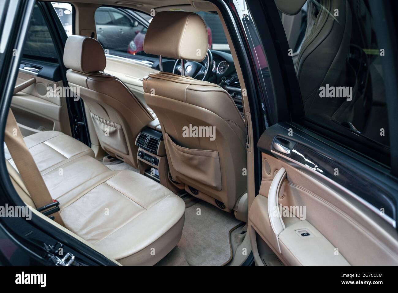 Modern luxury car inside. Comfortable beige leather seats and back passengers seat air conditioning control panel. Interior of a premium vehicle autom Stock Photo