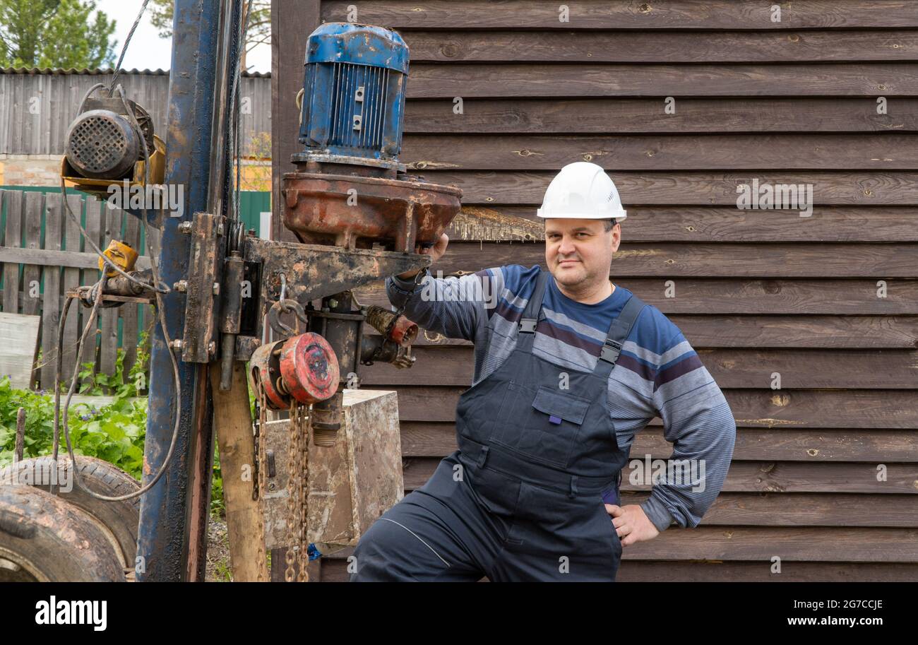 man stands near a drilling rig. drilling wells for drinking water Stock