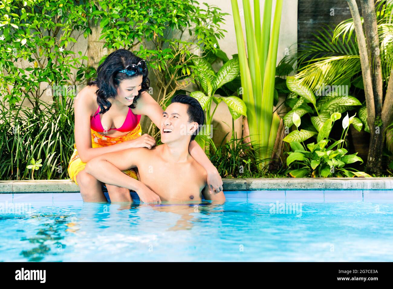 Asian couple swimming in hotel or club pool Stock Photo