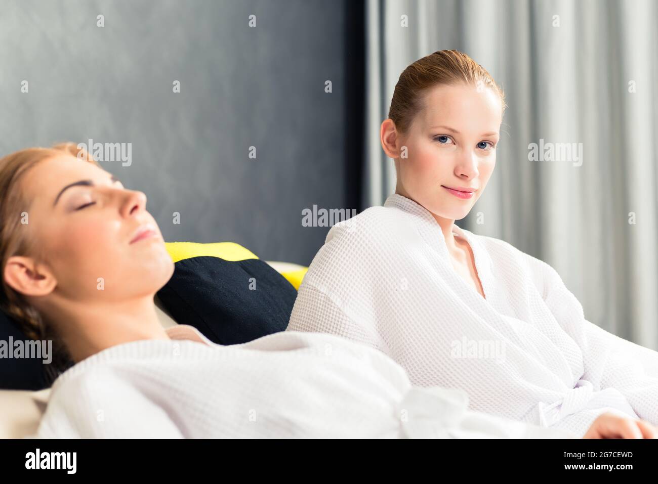 Two beautiful woman in bathrobe relaxing in spa Stock Photo