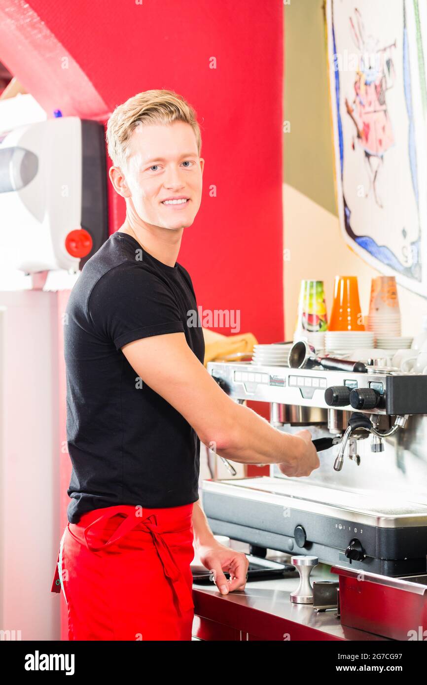 Barista using coffee machine or unit and preparing espresso or cappuccino in coffeehouse or shop