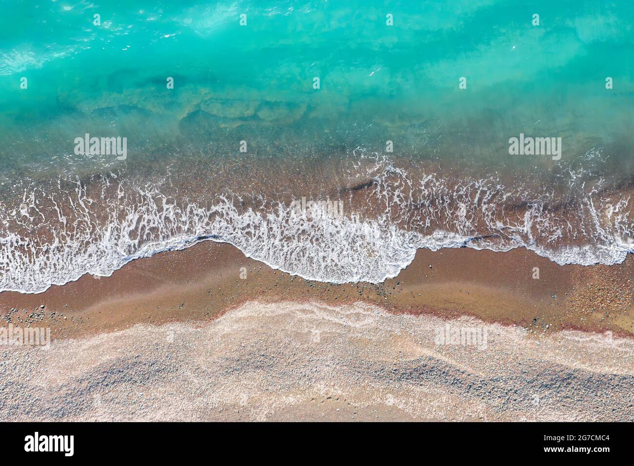 Sea waves breaking on a yellow sand shore, top view directly above Stock Photo