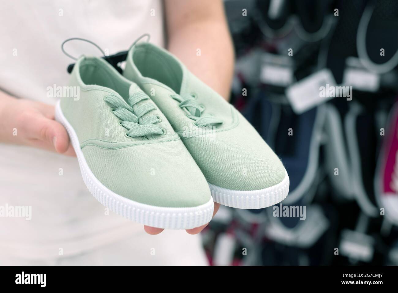 Green children's sneakers in the men's hands Stock Photo