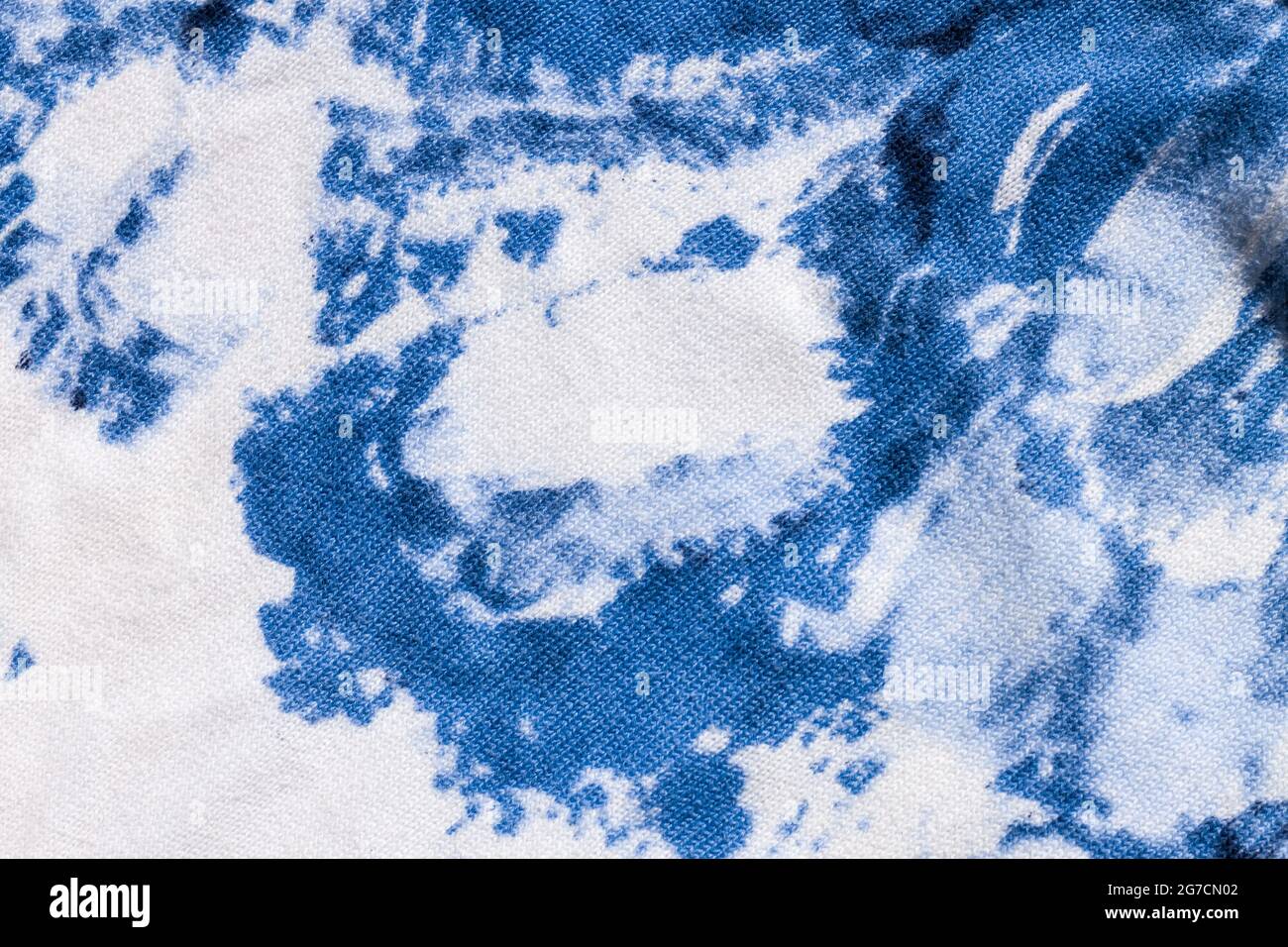 Tie-dye cotton fabric texture blue and white paint colors. Ancient resist-dyeing textile coloring technique, saturated primary colors, bold patterns, Stock Photo
