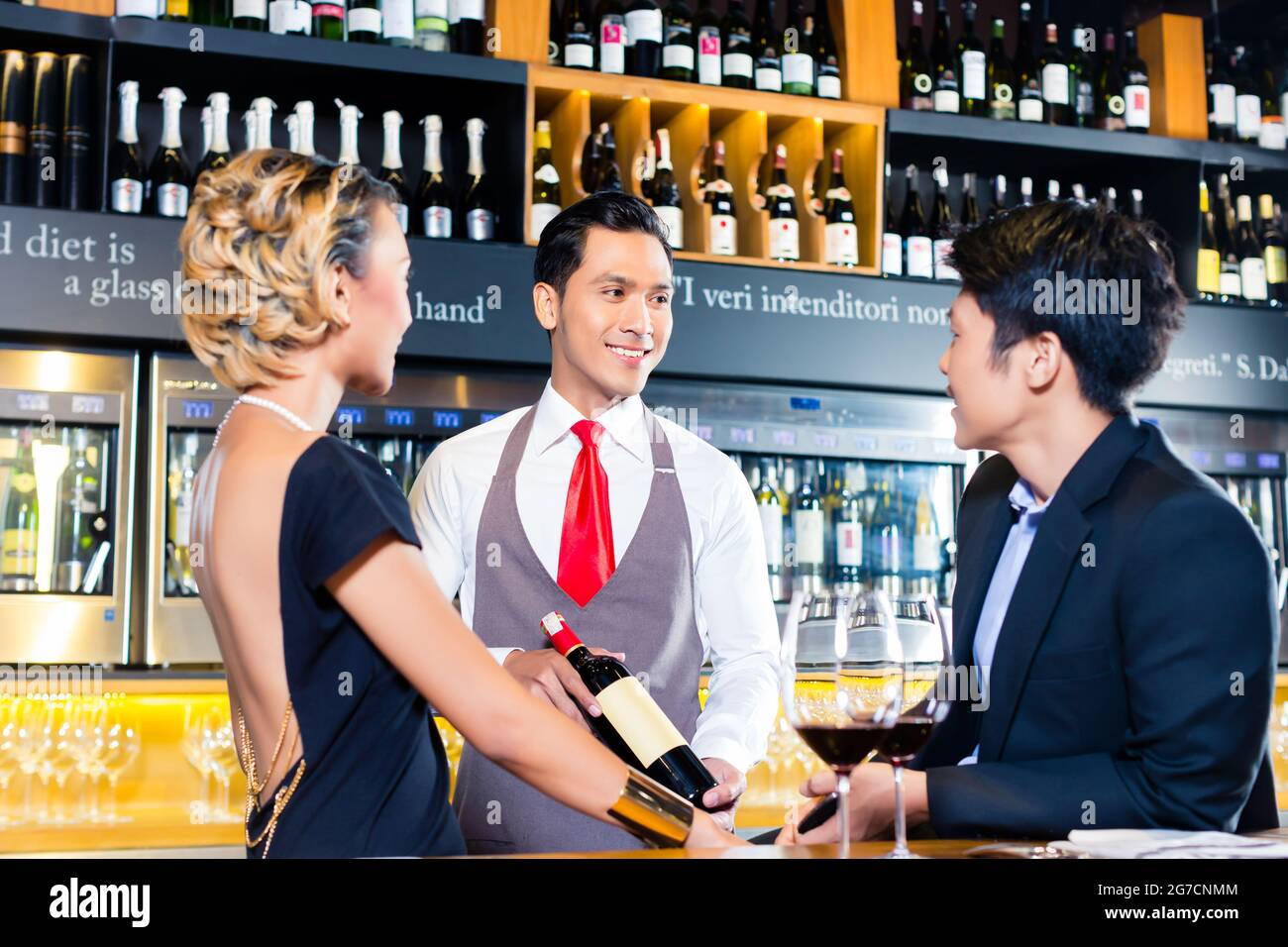 Asian couple tasting red wine in wine shope Stock Photo