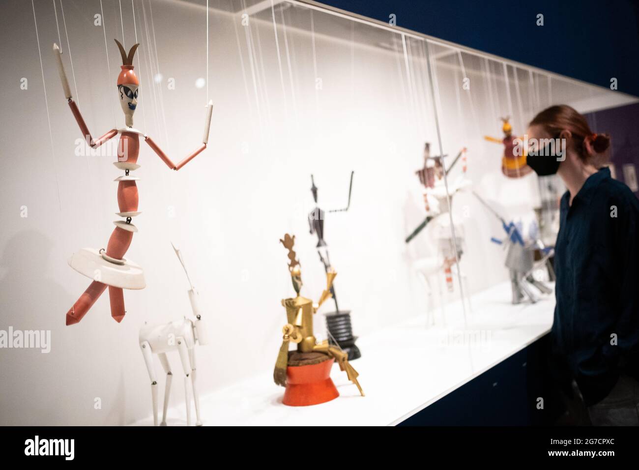 A person views 17 of Sophie Taeuber-Arp's Dada Marionettes King Stag string puppets on display during a photo call for the new Sophie Taeuber-Arp exhibition at the Tate Modern in London. Picture date: Tuesday July 13, 2021. Stock Photo