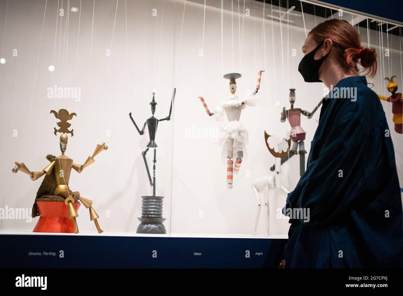 A person views 17 of Sophie Taeuber-Arp's Dada Marionettes King Stag string puppets on display during a photo call for the new Sophie Taeuber-Arp exhibition at the Tate Modern in London. Picture date: Tuesday July 13, 2021. Stock Photo