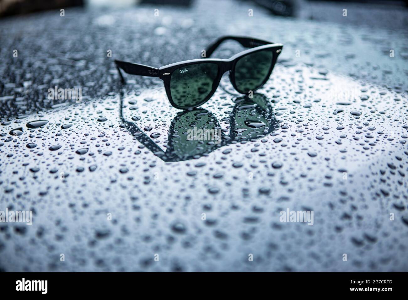 Ray Ban Wayfarer Sonnenbrille mit Regentropfen. Symboldbild Wetter, Sommer, Regenwetter, Regen Stock Photo